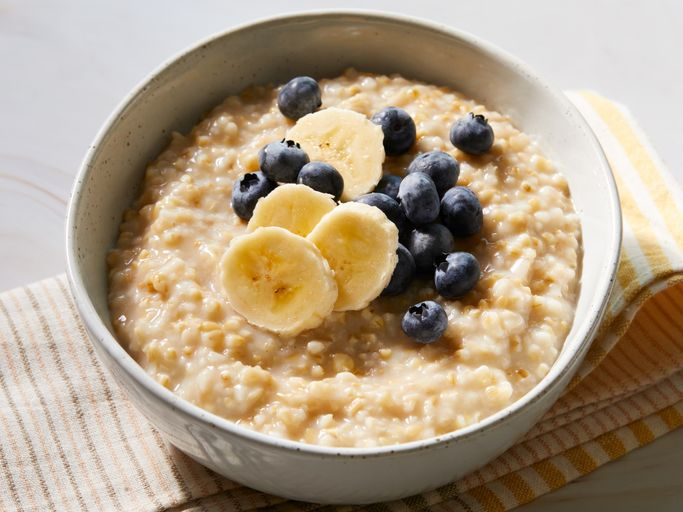 A bowl of oatmeal with banana and blueberries